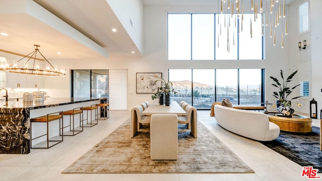 tiled dining space with a mountain view, a towering ceiling, and an inviting chandelier