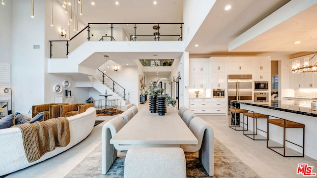 dining room featuring a towering ceiling and a notable chandelier