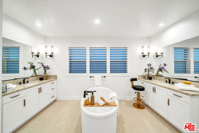 bathroom with vanity, a tub, and tile patterned floors