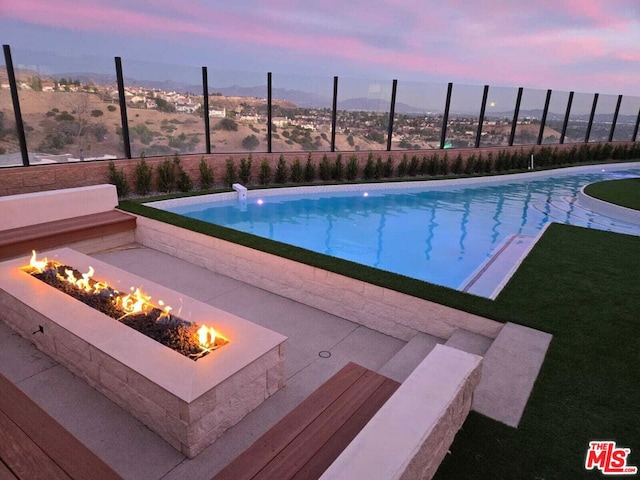 pool at dusk with an outdoor fire pit