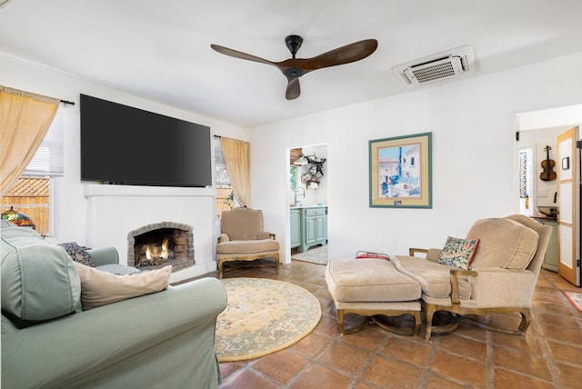 living room with tile patterned floors, ceiling fan, and a fireplace