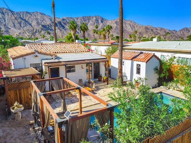 back of house with a mountain view and a patio