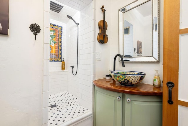 bathroom with vanity and tiled shower