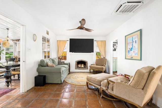 living room featuring ceiling fan and a fireplace