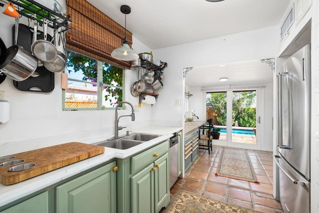 kitchen featuring sink, stainless steel appliances, green cabinets, decorative light fixtures, and light tile patterned floors