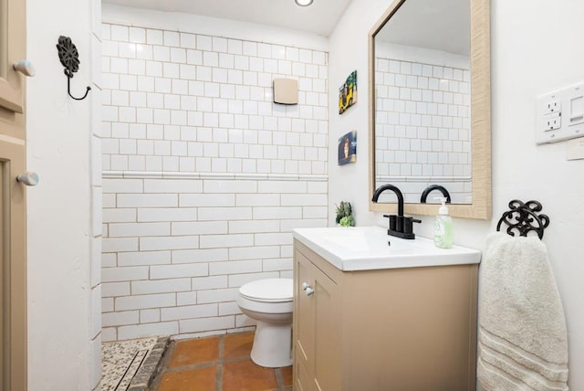 bathroom featuring tiled shower, vanity, and toilet