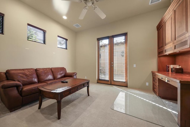 living room with ceiling fan, light colored carpet, and a healthy amount of sunlight