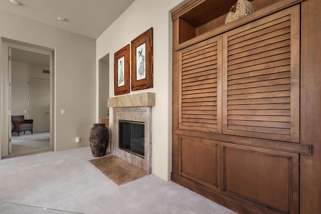 unfurnished living room featuring light colored carpet and a premium fireplace