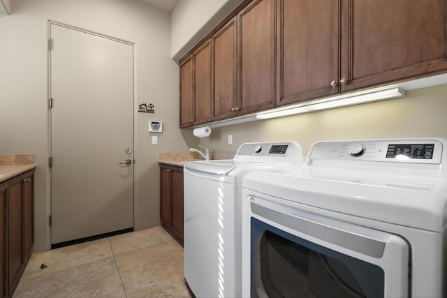 clothes washing area featuring light tile patterned flooring, cabinets, separate washer and dryer, and sink