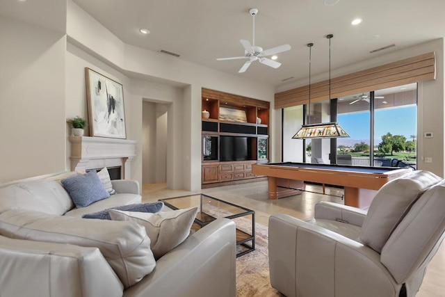 living room featuring built in features, ceiling fan, and pool table