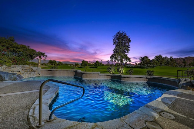 pool at dusk with pool water feature