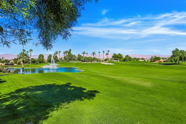 view of community featuring a lawn and a water and mountain view