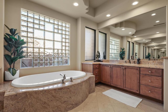 bathroom featuring vanity and tiled bath