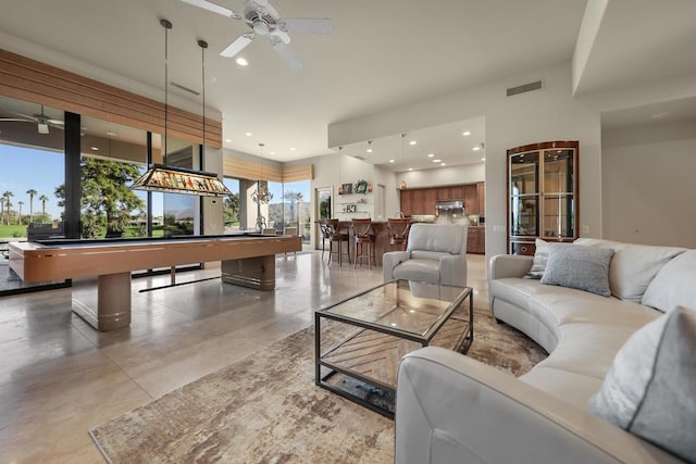 living room with ceiling fan, pool table, and concrete floors