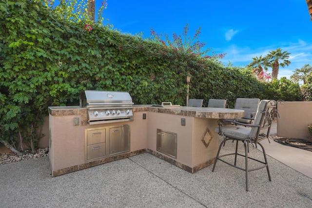 view of patio featuring area for grilling and exterior bar