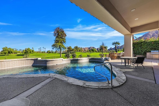 view of pool featuring a patio area, a yard, exterior kitchen, and an outdoor bar