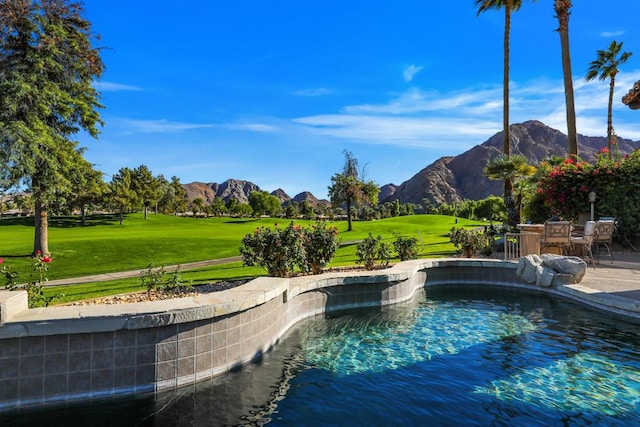 view of pool featuring a mountain view and a yard