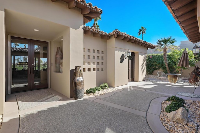 property entrance with a patio area and french doors