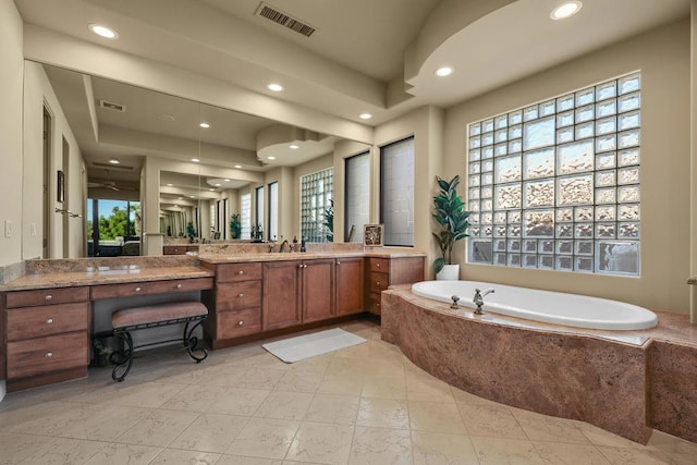 bathroom featuring vanity and tiled tub