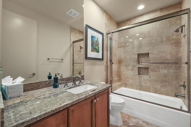 full bathroom featuring vanity, toilet, and shower / bath combination with glass door