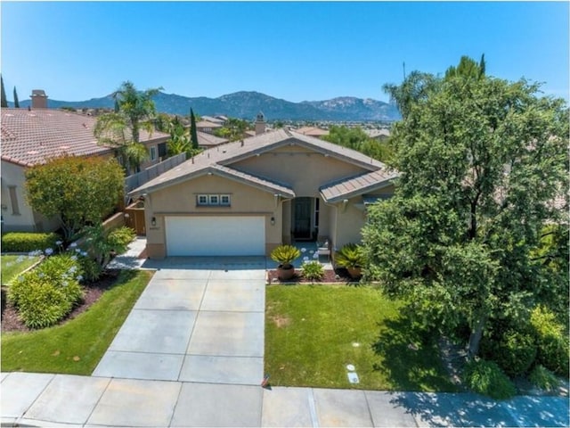 ranch-style house with a mountain view, a front lawn, and a garage