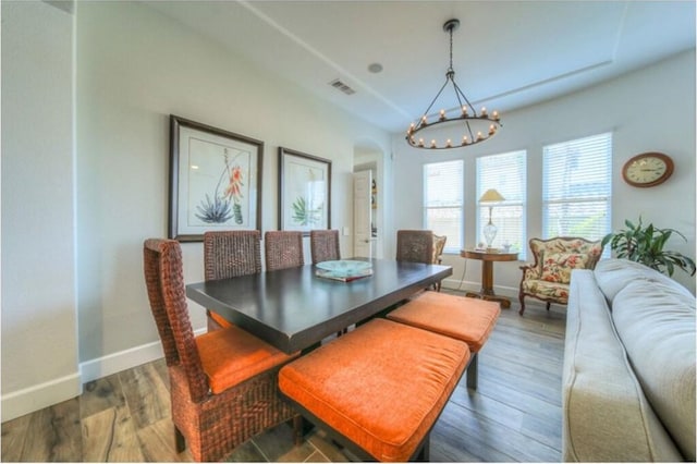 dining space featuring dark hardwood / wood-style flooring and an inviting chandelier