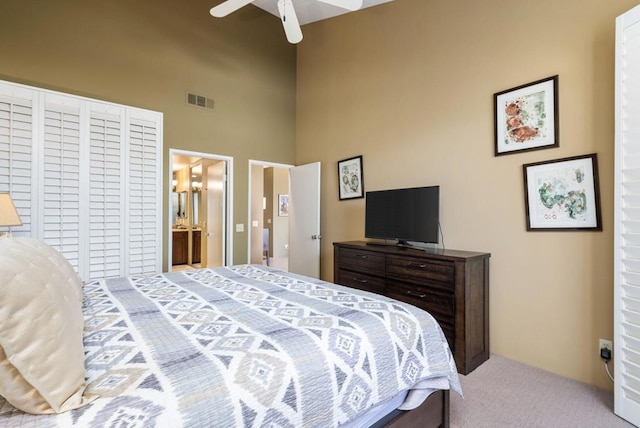 bedroom featuring ensuite bathroom, ceiling fan, and light colored carpet