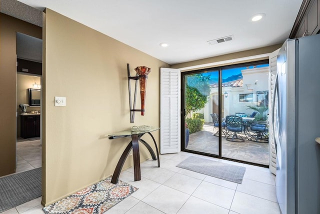 doorway to outside with light tile patterned floors