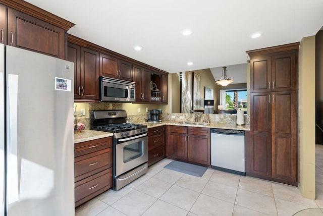 kitchen with light stone counters, sink, light tile patterned floors, and appliances with stainless steel finishes