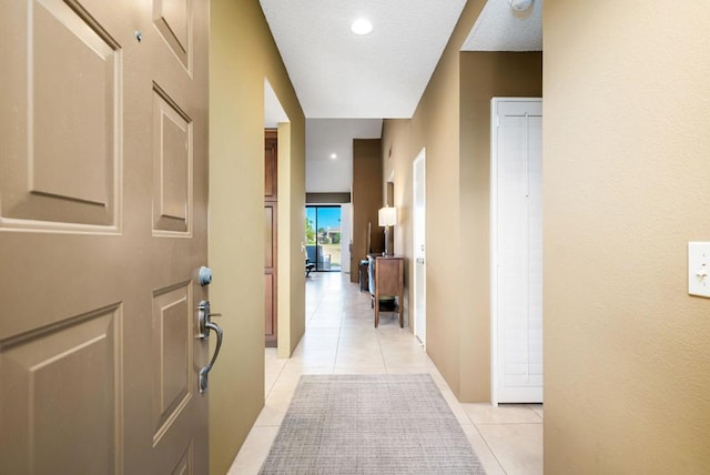 hallway with light tile patterned floors and a textured ceiling