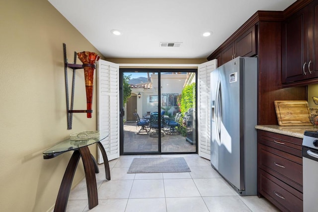 kitchen featuring light tile patterned floors and stainless steel refrigerator with ice dispenser