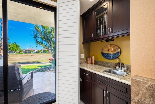 bar featuring dark brown cabinetry and sink