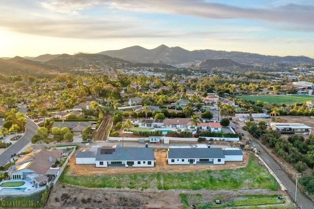 aerial view at dusk featuring a mountain view