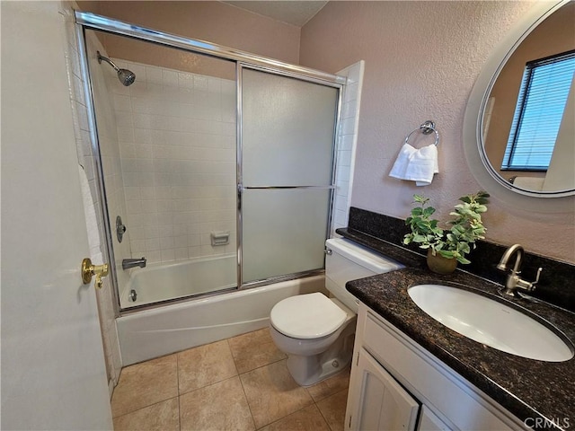 full bathroom featuring tile patterned flooring, vanity, shower / bath combination with glass door, and toilet