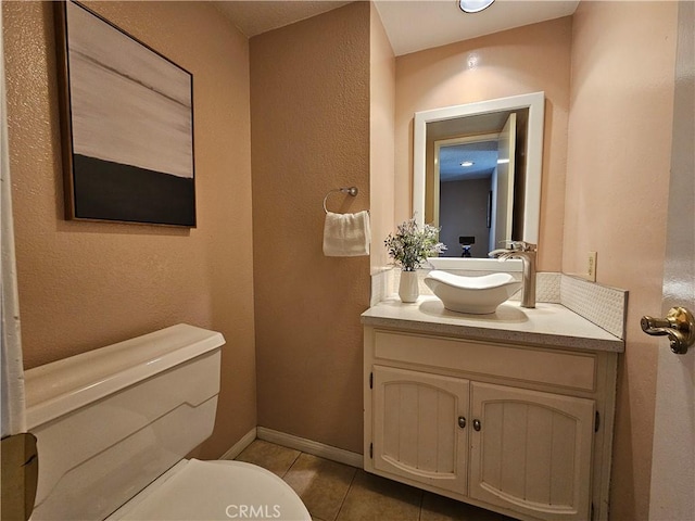 bathroom featuring vanity, tile patterned floors, and toilet