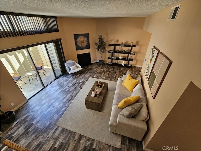 living room with lofted ceiling, dark hardwood / wood-style flooring, and a textured ceiling