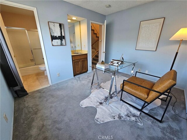 carpeted home office with sink and a textured ceiling