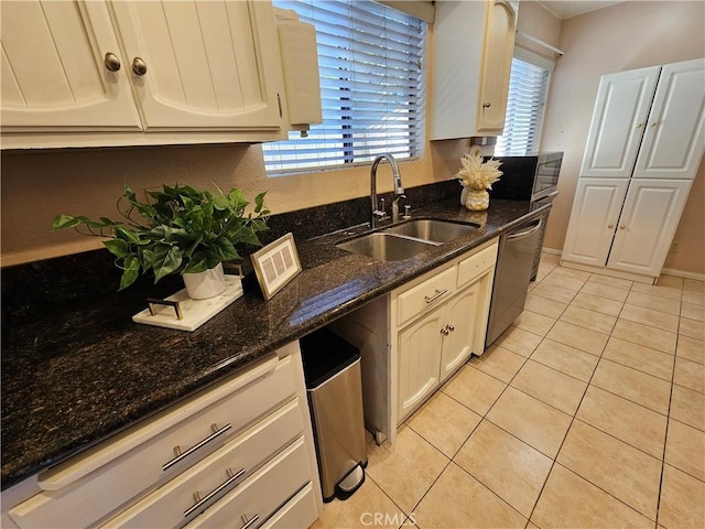 kitchen with white cabinetry, sink, light tile patterned floors, and dishwasher