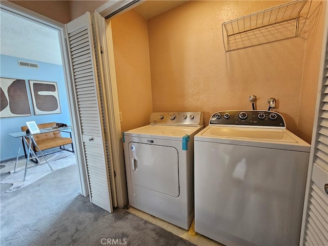 laundry room featuring light carpet and washing machine and dryer