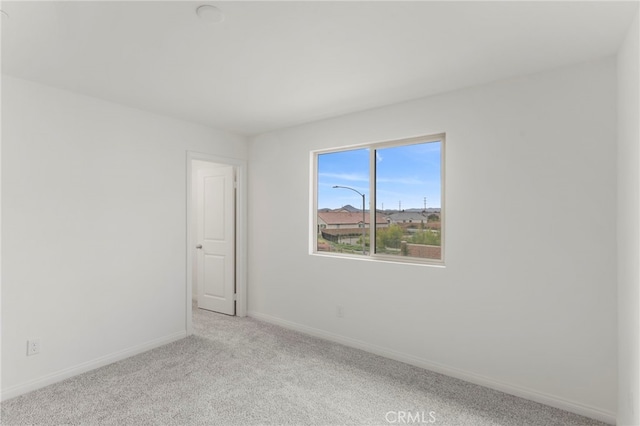 unfurnished room featuring light carpet