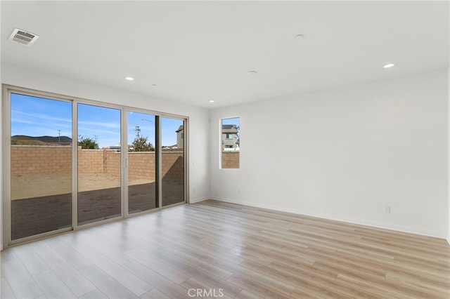 empty room with light hardwood / wood-style flooring