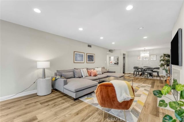 living room with a chandelier and light wood-type flooring