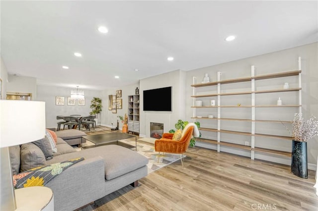 living room with a chandelier and light wood-type flooring