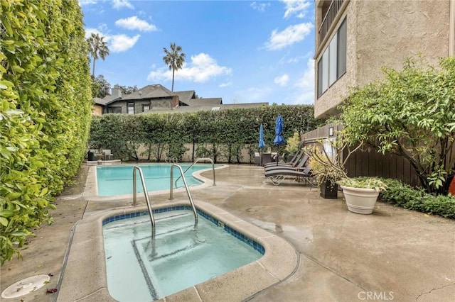 view of swimming pool with a hot tub and a patio