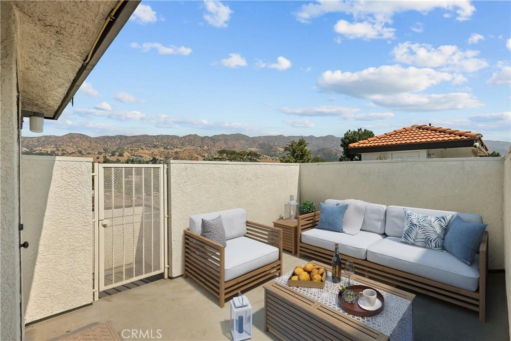 view of patio / terrace featuring a gate, a mountain view, a balcony, and an outdoor hangout area