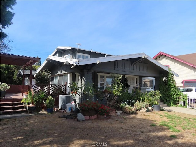 view of front of property with a pergola, a wooden deck, and cooling unit