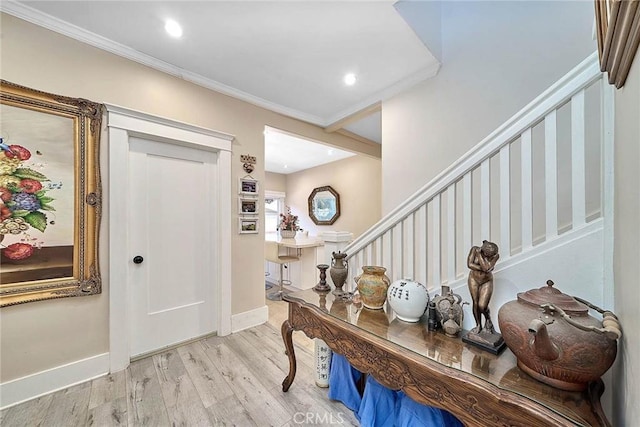 foyer with light hardwood / wood-style flooring and crown molding