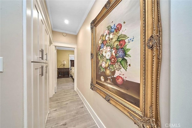 corridor featuring ornamental molding and light hardwood / wood-style flooring