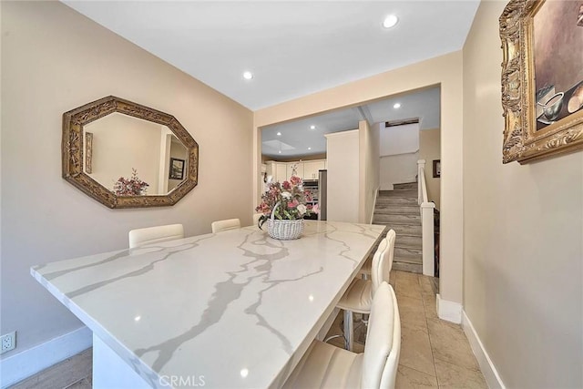 interior space featuring a breakfast bar and light stone counters