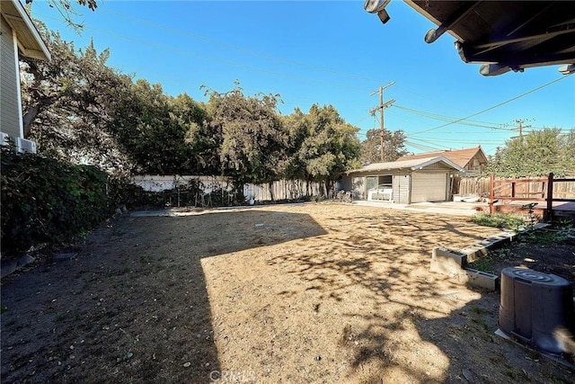 view of yard featuring a garage and an outbuilding